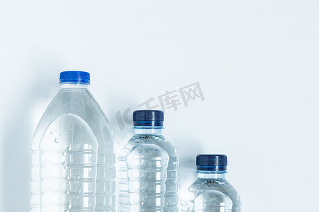 蓝色的矿泉水瓶子摄影照片_从上面装满矿泉水的三个塑料瓶