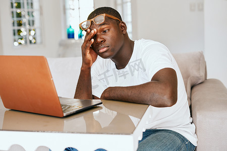 电脑前疲劳的人摄影照片_笔记本电脑前桌子旁的男人非洲人外表疲劳