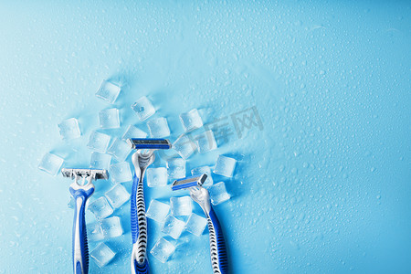 冷淡摄影照片_冷淡的蓝色背景上的三台剃须机加冰。