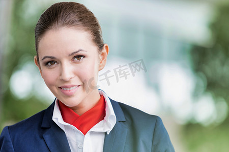 机场飞行显示器前站立的年轻漂亮空姐的肖像