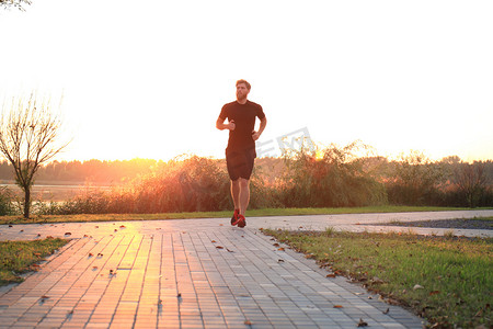 运动的年轻人在户外跑步以保持健康，在日落或日出。