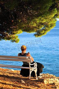 单身女人独自坐在海边