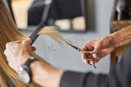 理发师正在为金发女人剪头发是沙龙