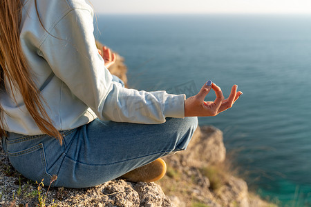 瑜伽、手势和健康的生活方式概念 — 冥想瑜伽女人的手在海上日落背景下展示 gyan mudra