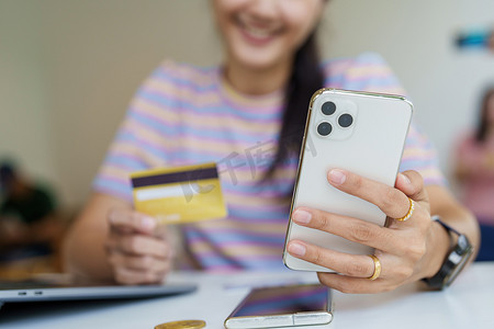 网上购物和互联网支付，美丽的亚洲女性肖像正在使用信用卡和手机在网上购物或在数字世界中办事