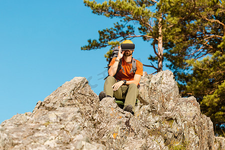 成功的年轻人，使用虚拟现实护目镜在山中游览，夏天度假