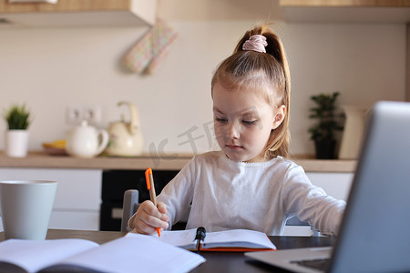 严肃的小女孩在家使用笔记本电脑在线学习手写，可爱快乐的小孩在 PC 上上互联网课程或课程。