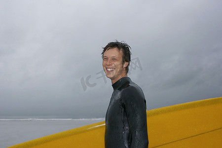 冲浪者在海滩肖像侧视上携带冲浪板