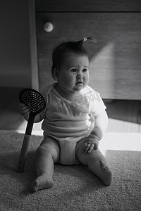 一张 7 个月大女孩的黑白照片坐在地毯上