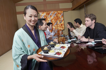 女服务员将寿司送到餐厅