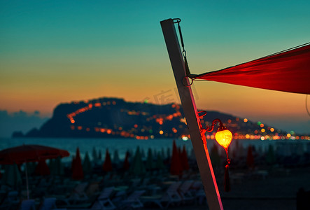 红色利是摄影照片_日落时海滩上的灯笼，背景是阿拉尼亚半岛