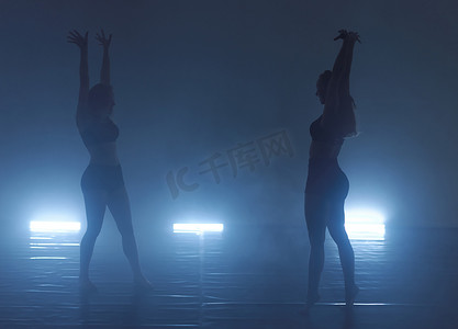 女性舞伴摄影照片_黑暗环境中的一对女性运动舞伴
