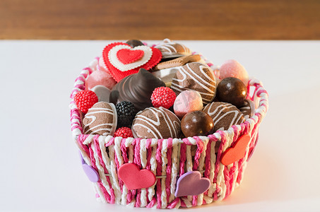 情人节的糖果、饼干和装饰心放在篮子里。