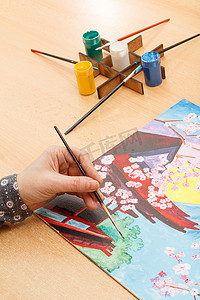 创意手绘风景摄影照片_女人的手绘画日本风景艺术家在车间