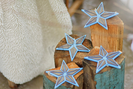 扁平星辰摄影照片_圣诞装饰：木制扁平蓝星小雕像，在木柱上