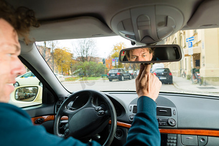 出租车司机摄影照片_出租车司机正在照镜子