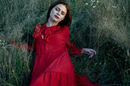 女人躺在草地上，穿着红色的风景时尚