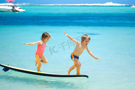 双胞胎兄妹在海里冲浪的乐趣。