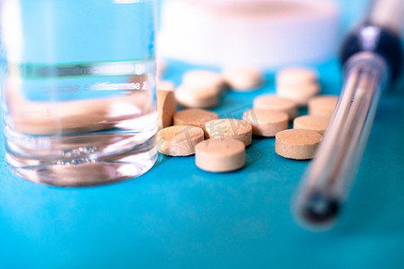 蓝色背景上显示玻璃安瓿、瓶子、药片、注射器的照片显示了被用作治疗 covid19 冠状病毒的抗病毒药物的各种药物和治疗方法。