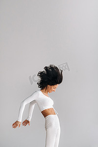 一位身穿白色运动服的女士正在瑜伽馆进行动态卡利冥想