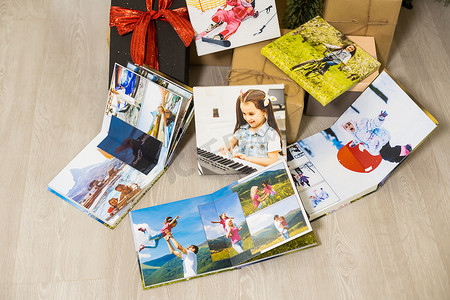圣诞树附近的照片画布和照片书作为礼物