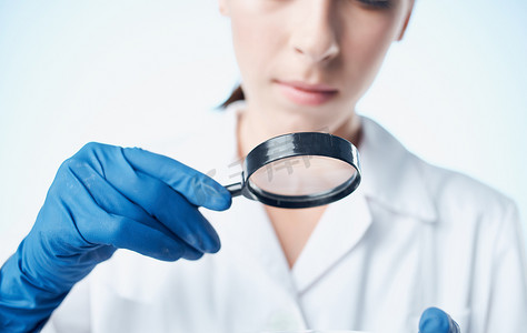 戴蓝色手套的女医生，在医用长袍疫苗化学元素实验室