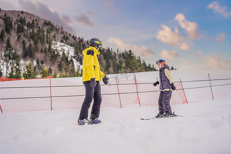 安全指导员摄影照片_和教练一起学习滑雪的女人。