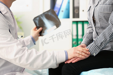 pe管合格证摄影照片_有肺部 X 光扫描的合格男性医生在预约时让女性患者平静下来