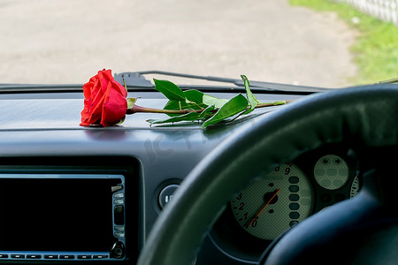 车内仪表板上有一朵红玫瑰花