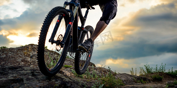 专业自行车手在日落时骑自行车下落基山。