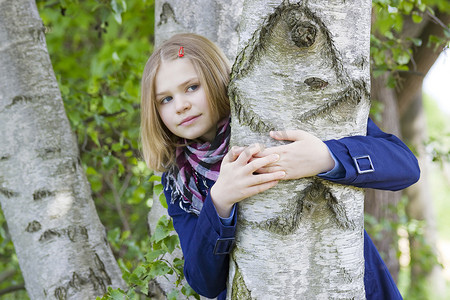 女孩抱着树干微笑