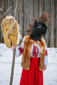 漫画头像女生摄影照片_一个身着动物头像民族服装的男子庆祝异教节日 Maslenitsa 的到来。