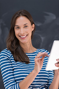 在粉笔画板前使用平板电脑的女人