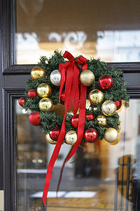 冷杉树枝圣诞花环，屋子透明门上挂着棉花花