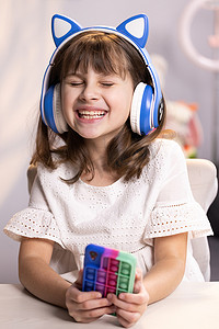 快乐的时髦少女戴着耳机在客厅里听 dj 流行音乐。