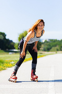 炎炎夏日户外柏油路上的轮滑女孩