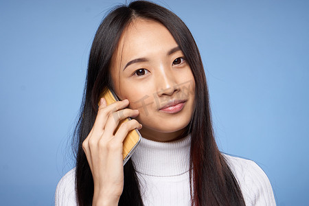 可爱聊天摄影照片_可爱的亚洲女人在电话里聊天科技蓝色背景