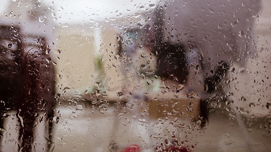 彩色雨滴背景摄影照片_雨季雨滴在湿窗玻璃表面。