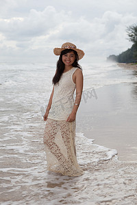 海边女子摄影照片_穿着长裙的亚洲年轻女子的笑脸肖像
