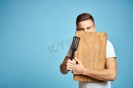 精力充沛的人摄影照片_精力充沛的家伙，带着木制厨房板和抹刀有趣的情绪