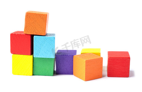 白色背景上的木制彩色建筑立方体玩具块。
