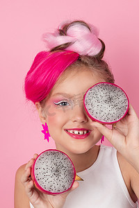 粉色火龙果摄影照片_粉红色发型的漂亮女孩的特写肖像，粉红色背景上有火龙果。