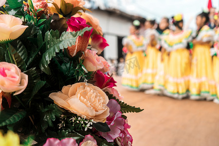 一群面目全非的尼加拉瓜民间传说舞者在鲜花盛开的舞台上