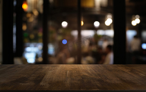 咖啡背景摄影照片_抽象模糊散景背景前的空暗木桌