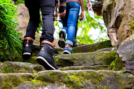 徒步旅行者的脚在岩石上行走的特写镜头