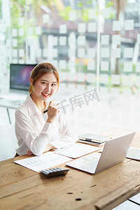 数据分析、计划、营销、会计、审计、亚洲女商人计划营销的肖像使用统计数据表和计算机在会议上展示营销计划项目。
