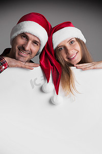 情侣海报摄影照片_戴着圣诞老人帽子的情侣