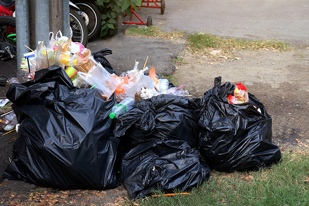 地板上堆满垃圾塑料黑色和垃圾袋废物，污染垃圾，塑料废物和袋子泡沫托盘，地板上许多垃圾，废塑料