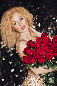 红色发束摄影照片_完美迷人的女士与一束红玫瑰。