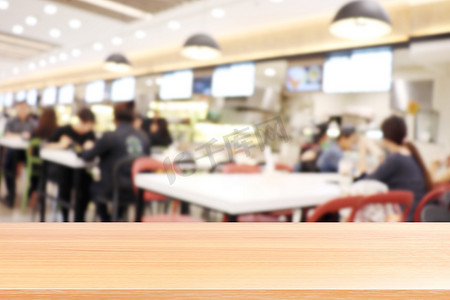 食堂摄影照片_模糊食堂餐厅的木板，很多人在大学食堂模糊背景中吃食物的空木桌地板，模糊咖啡馆或自助餐厅食堂的木桌板空着